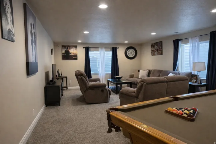 Spacious recreation room featuring recessed lighting, light beige walls, and carpet flooring
