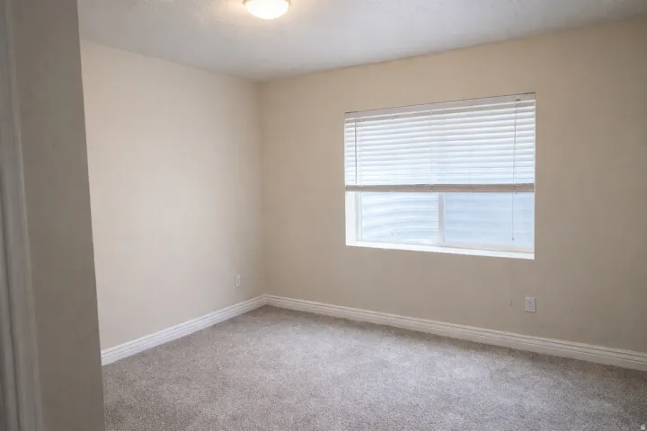 Carpeted spare room featuring baseboards