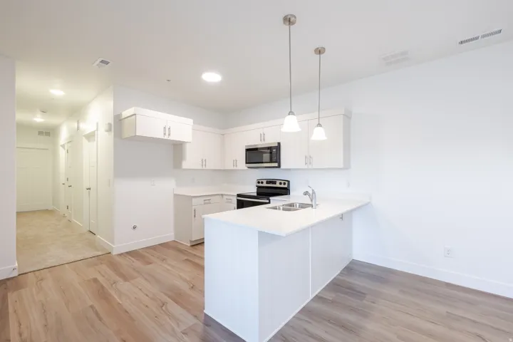 Modern kitchen featuring white cabinetry, light countertops, and stainless steel appliances