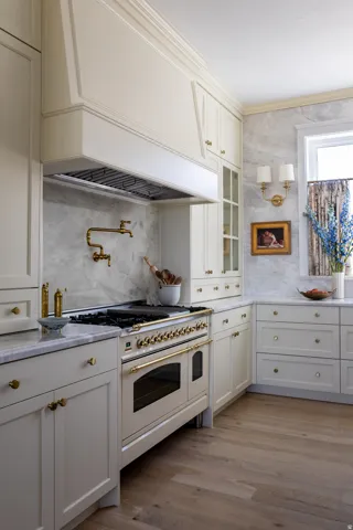 Kitchen featuring Italian gas range with two ovens, hardwood wood flooring, and marble countertops