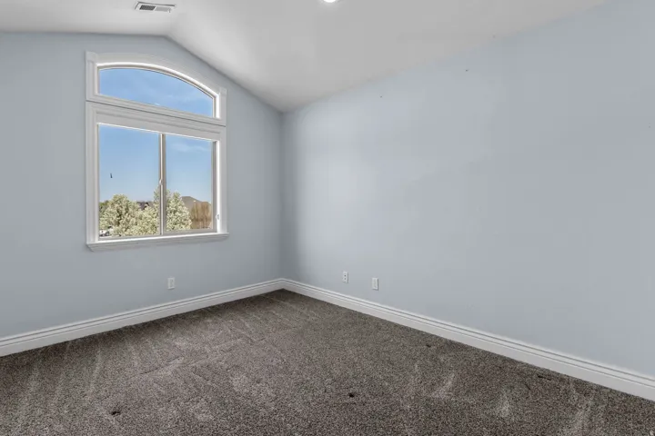 Empty room featuring dark colored carpet and baseboards