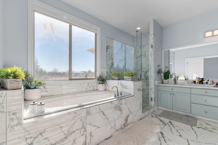 Primary Bathroom featuring a marble finish shower, vanity, a garden tub, light marble finish flooring, and recessed lighting