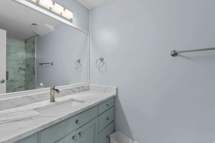 Full bath with vanity and a marble finish shower