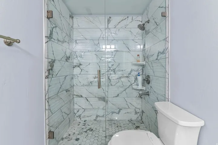 Bathroom with toilet and a marble finish shower