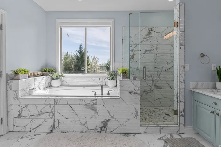 Bathroom with a marble finish shower, light marble finish flooring, and a bath