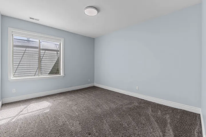 Carpeted empty room with baseboards
