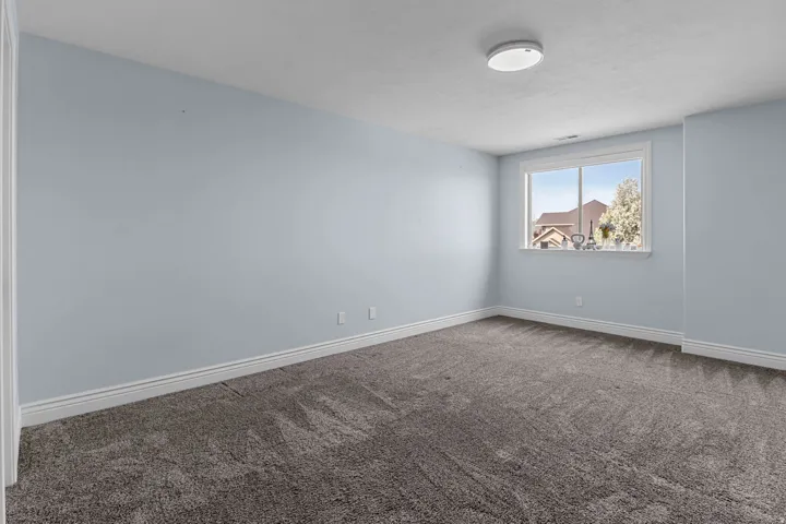 Spare room with dark carpet and baseboards