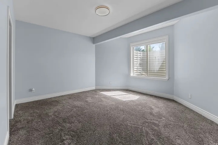 Carpeted spare room featuring baseboards