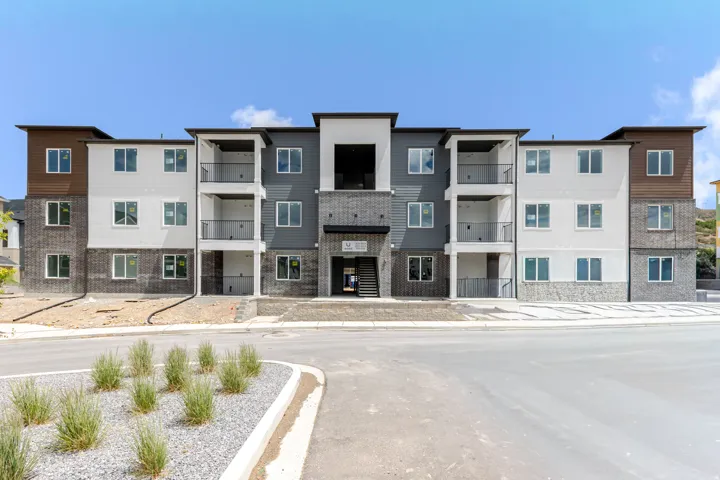 Contemporary multi-story building featuring a brick and siding facade with varied tones of white, grey, and brown