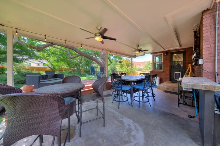 View of patio / terrace featuring outdoor dining area and a ceiling fan - Oasis in the city.