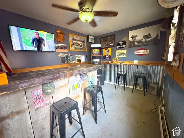 Party time! Indoor dry bar with concrete floors, ceiling fan, and wood counters