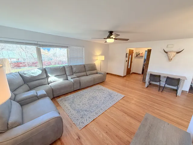 Living area featuring light wood finished floors and a ceiling fan