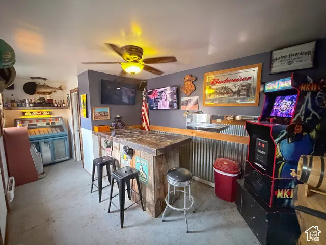 Fun Indoor dry bar with unfinished concrete floors and ceiling fan
