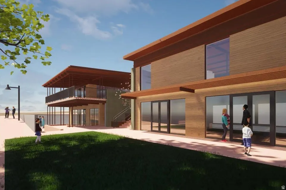 Rear view of house featuring a balcony, a patio, and a lawn