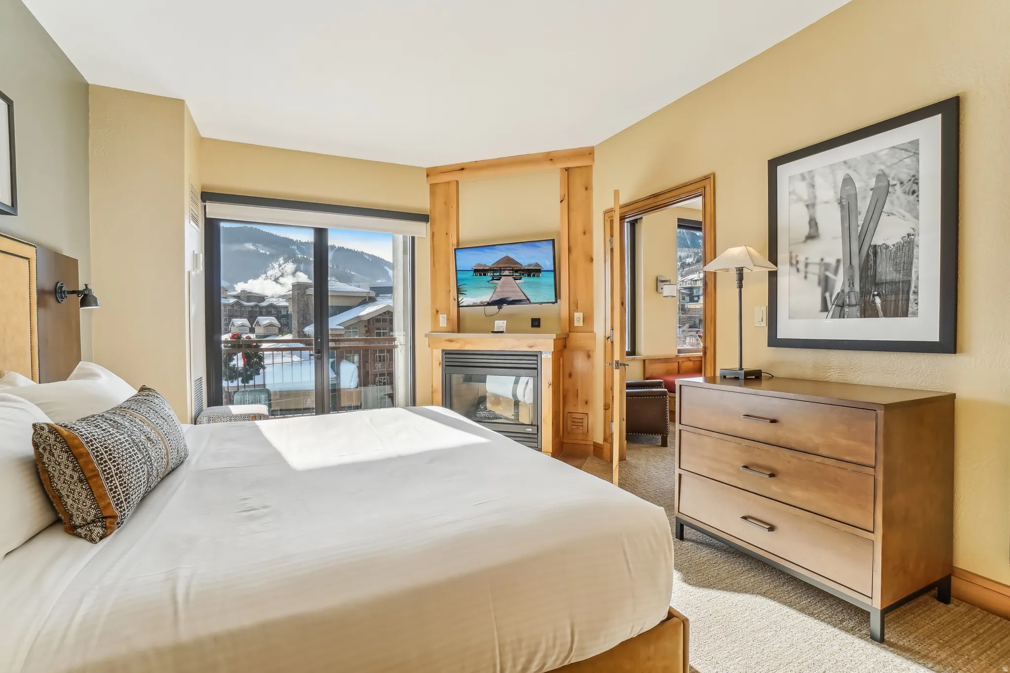 Bedroom with access to outside, light colored carpet, and a multi sided fireplace