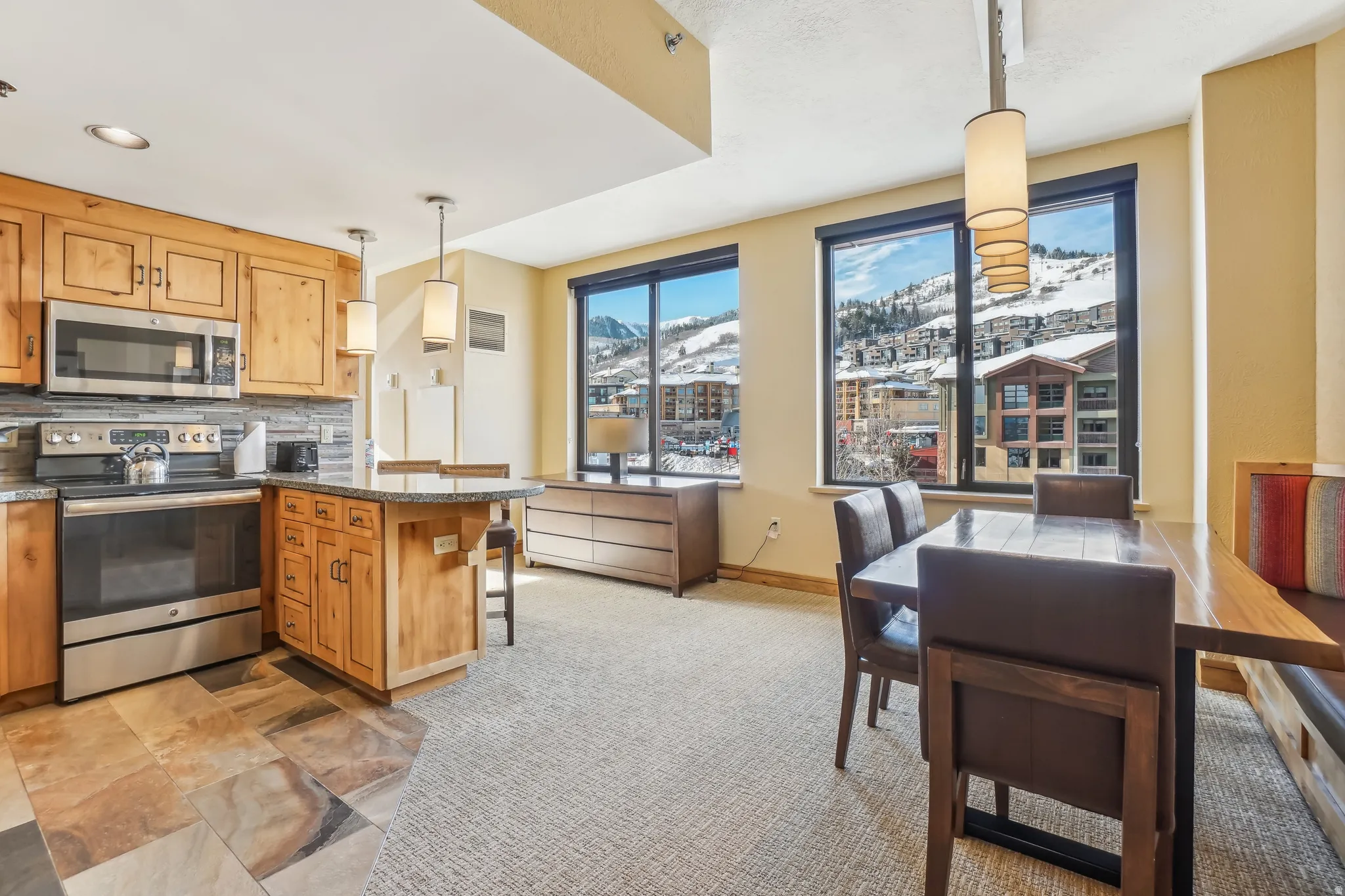 Kitchen with stainless steel appliances, backsplash, pendant lighting, a peninsula, and a kitchen breakfast bar