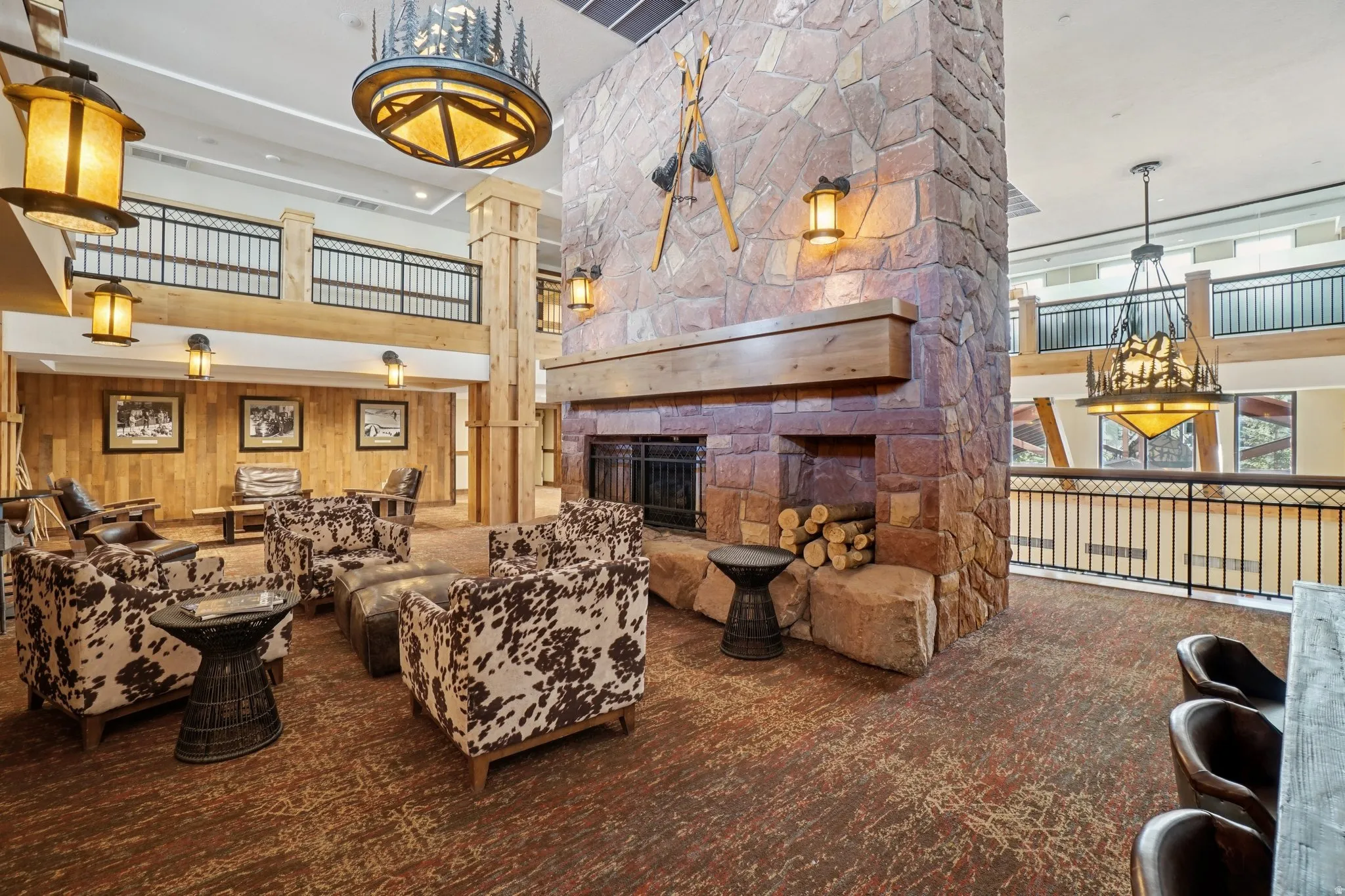 Carpeted living area featuring a high ceiling, a fireplace, and wood walls