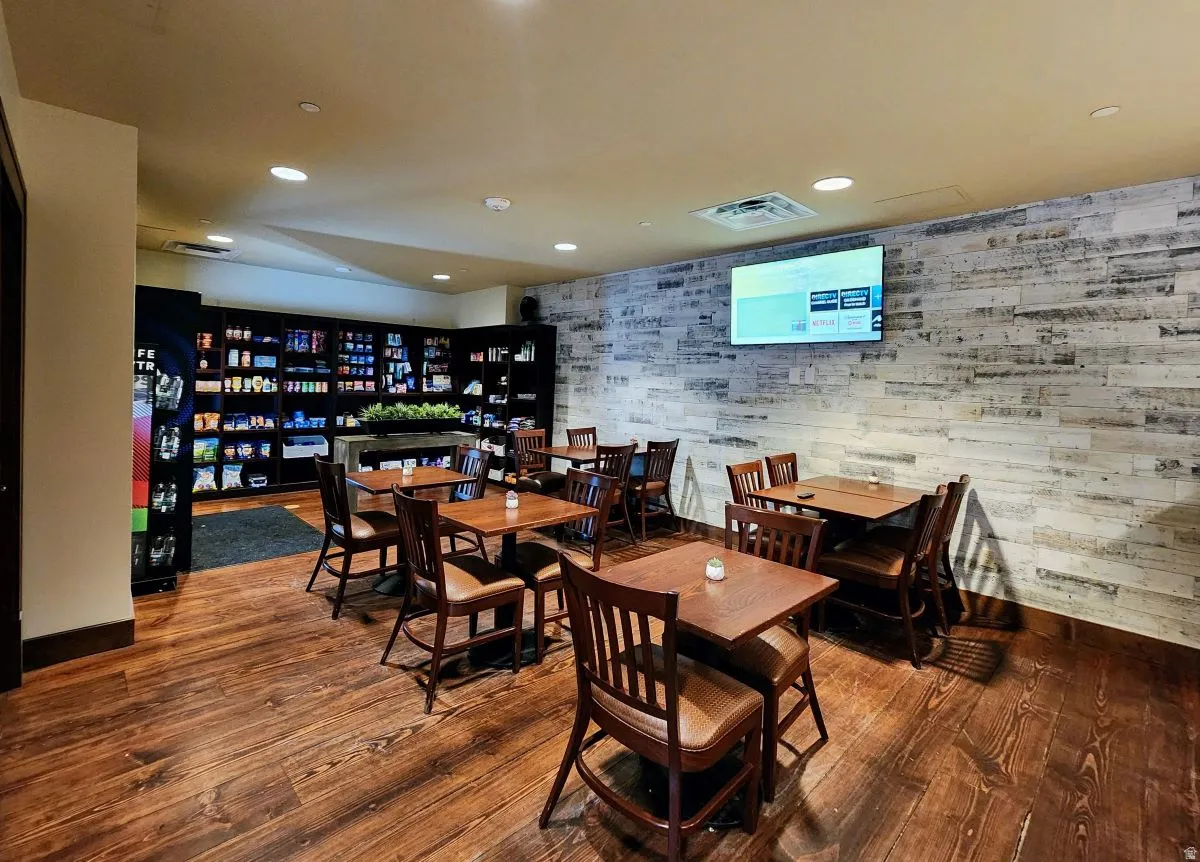 Dining room with hardwood / wood-style floors, recessed lighting, and wood walls