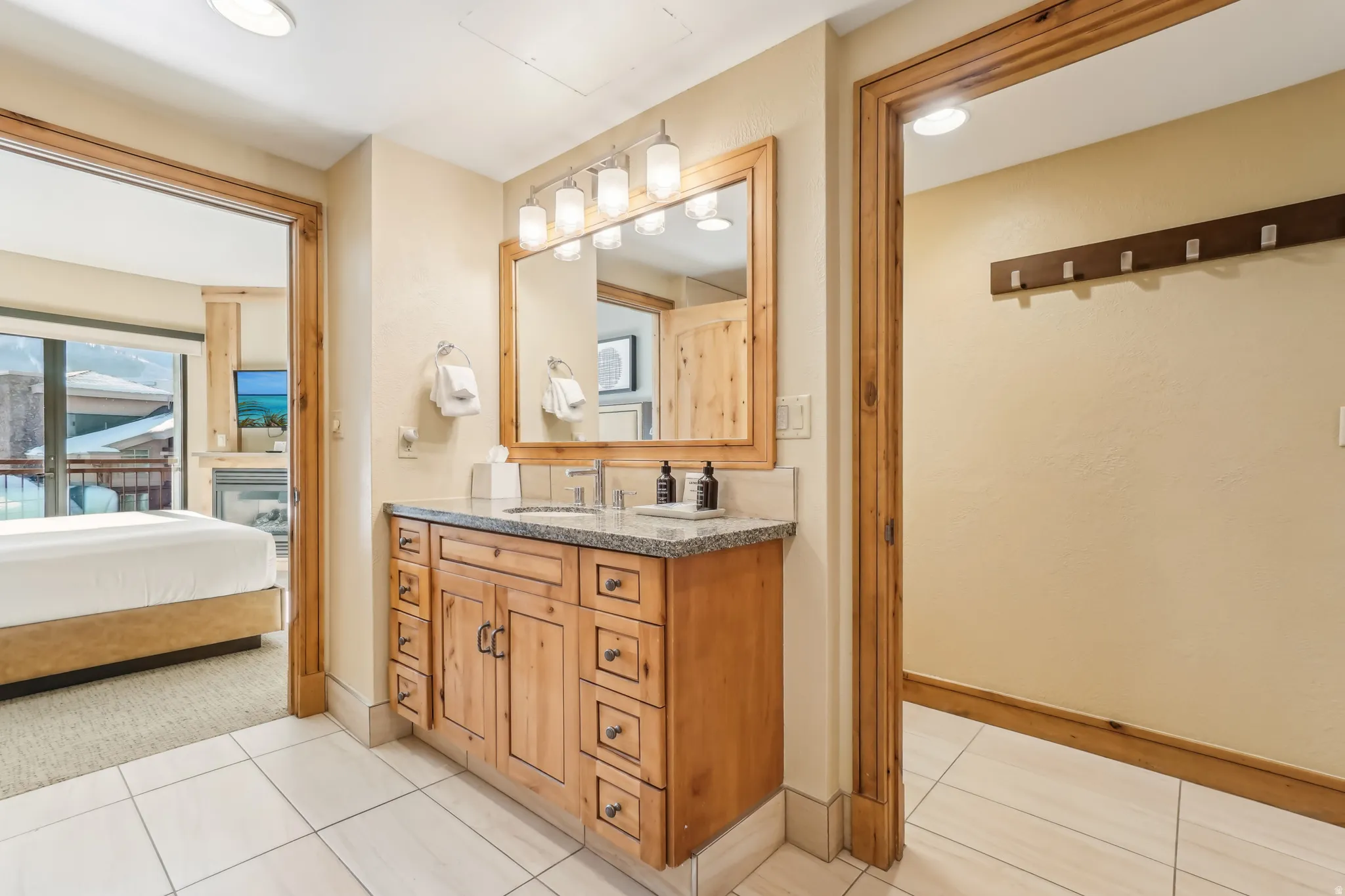 Bathroom with vanity, ensuite bath, and light tile patterned flooring