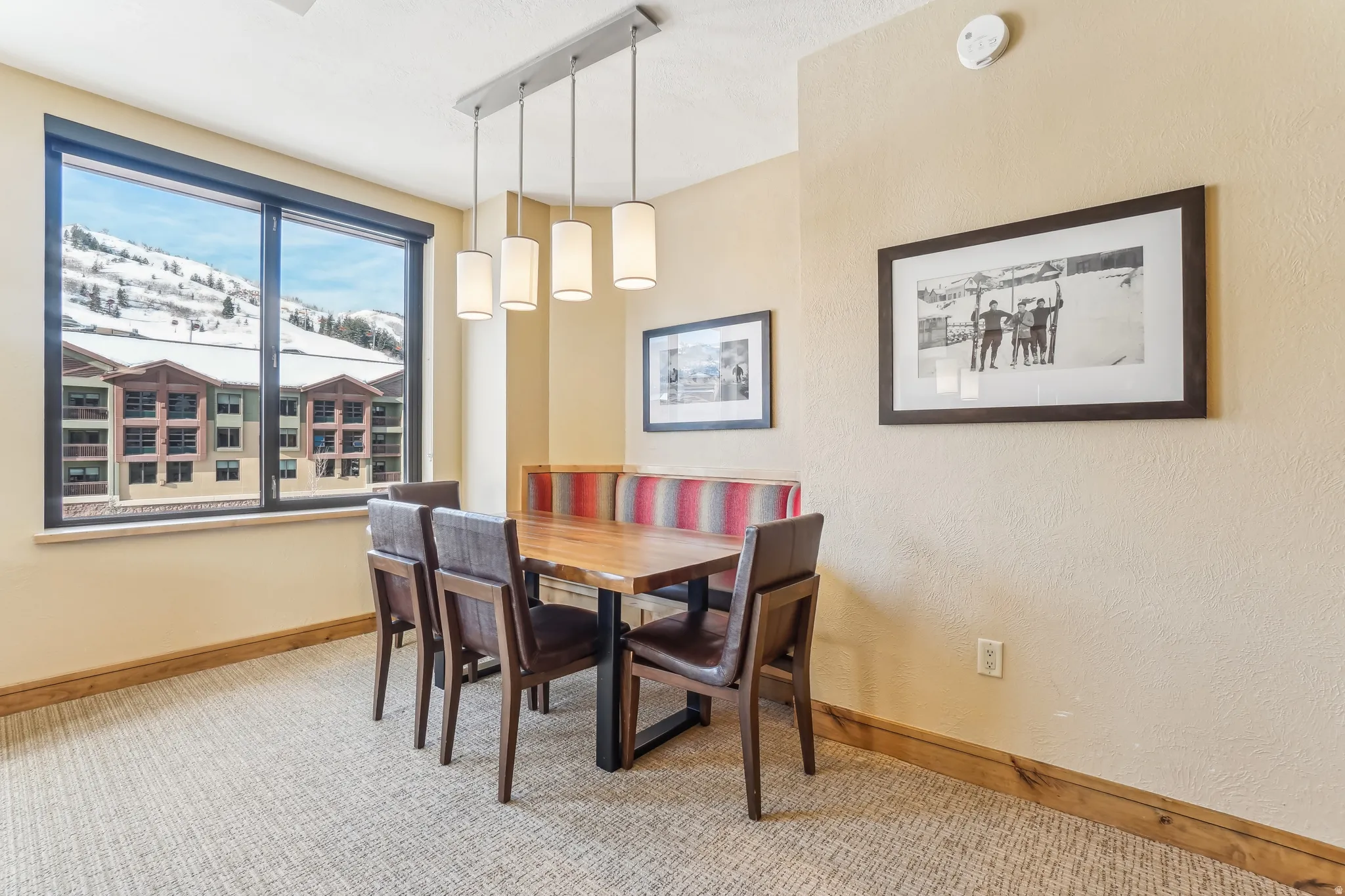 Carpeted dining area with baseboards and a textured wall