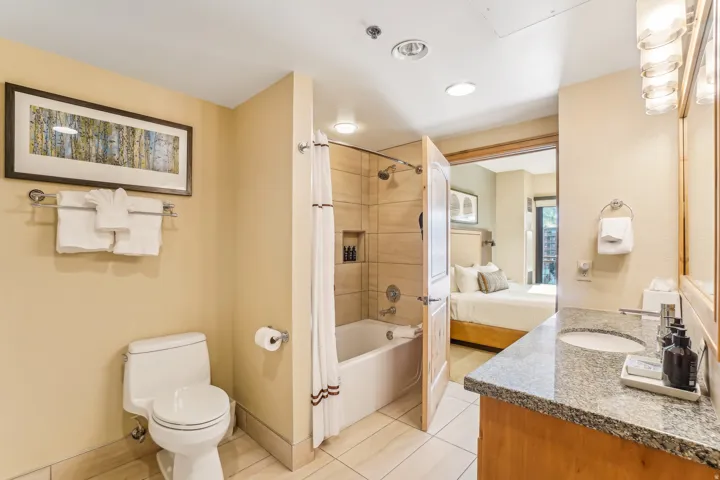 Full bathroom with vanity, shower / bathtub combination with curtain, ensuite bath, and light tile patterned floors