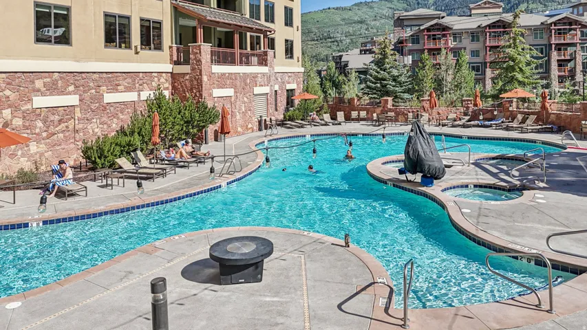 Community pool with a patio, a hot tub, and a mountain view