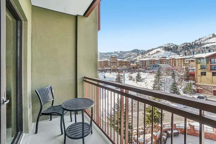 Snow covered back of property with a mountain view