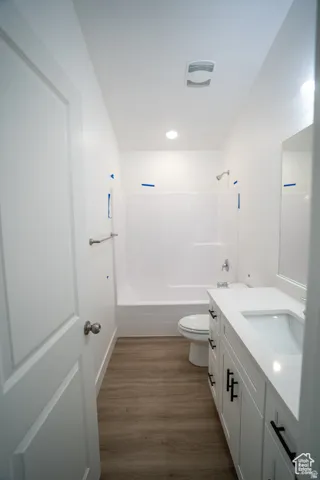 Bathroom featuring bathtub / shower combination, dark wood finished floors, and vanity