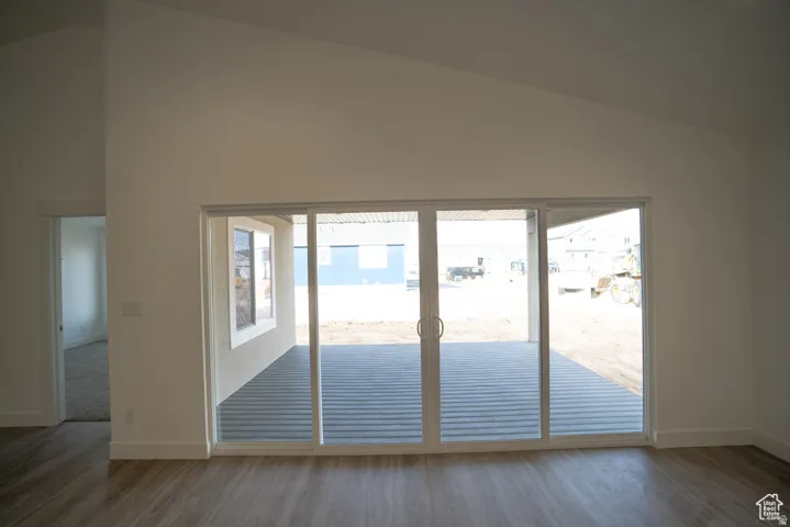 Doorway featuring vaulted ceiling and wood finished floors