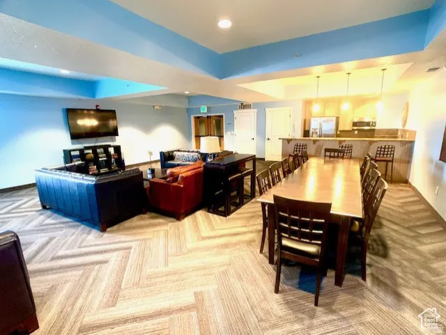 Dining space with light carpet, a tray ceiling, and recessed lighting