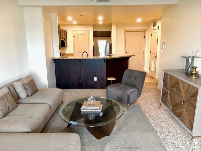 Living room featuring light colored carpet and recessed lighting