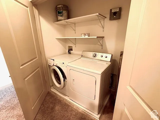 Laundry area with washer and clothes dryer and carpet flooring