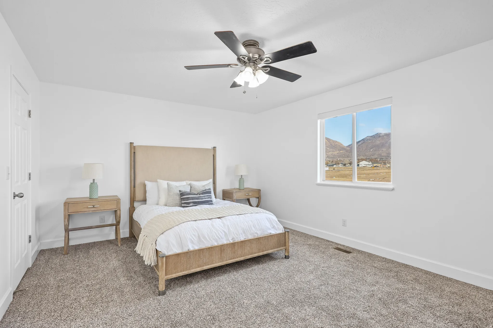 Primary Bedroom with a mountain view, a ceiling fan, and NEW carpet.