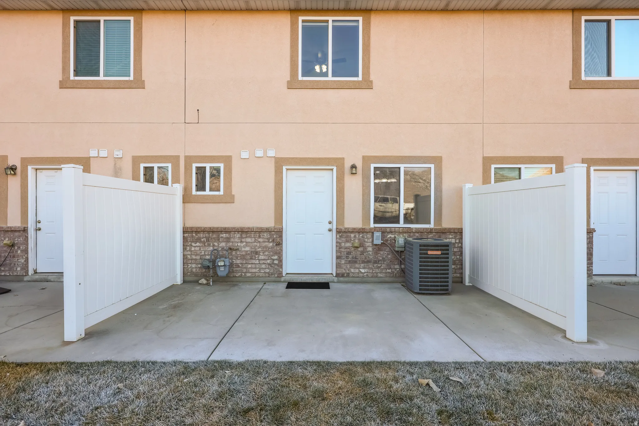 Rear view of property featuring a patio, brick siding, and stucco siding