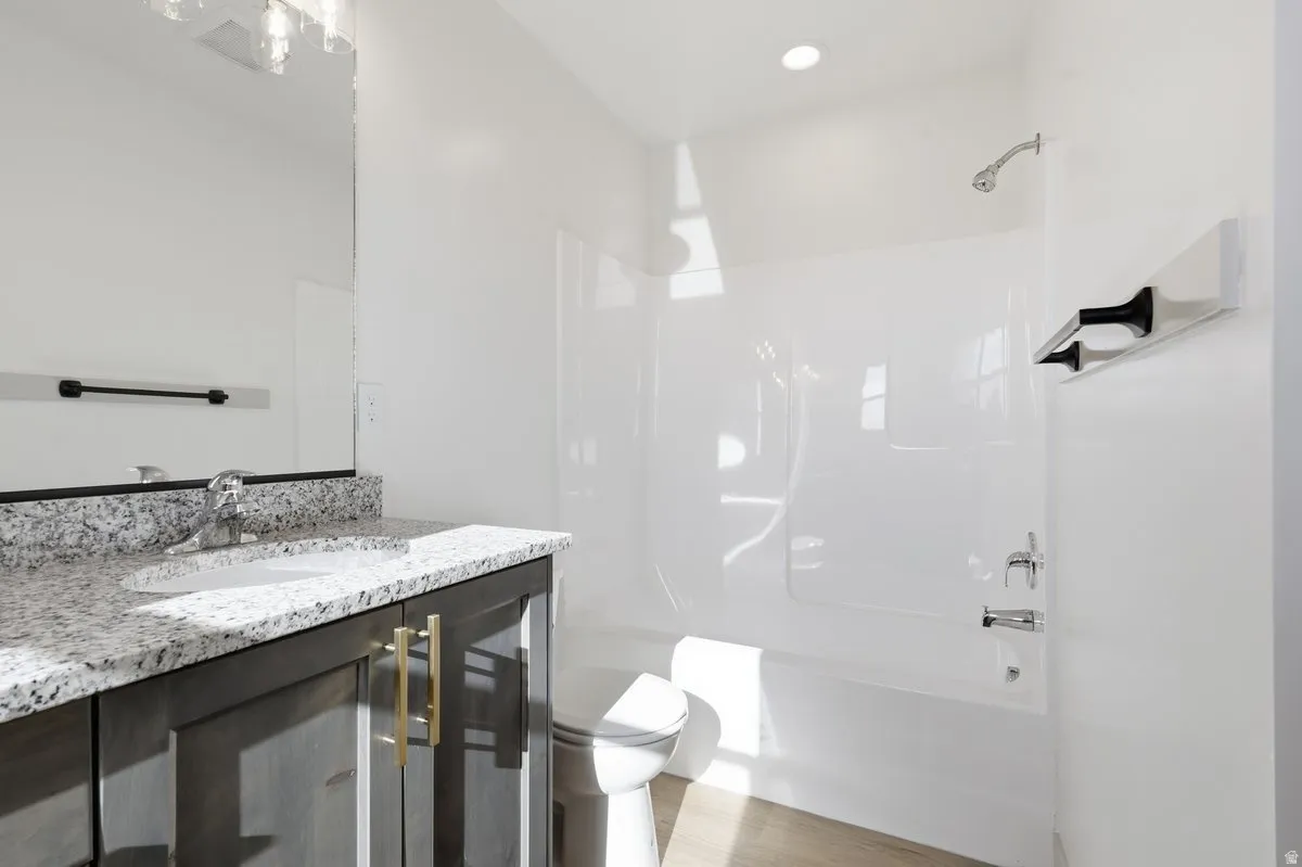 Bathroom with vanity, bathtub / shower combination, and light wood-type flooring