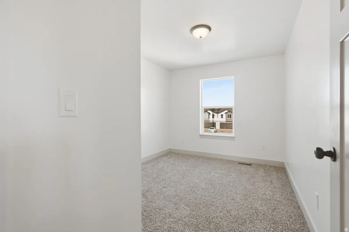 Unfurnished room featuring light colored carpet and baseboards