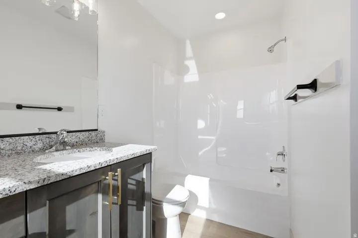 Bathroom with vanity, bathtub / shower combination, and light wood-type flooring