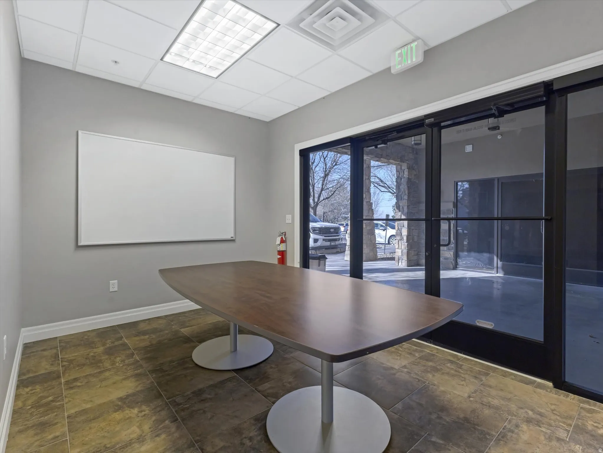 Dining area with a drop ceiling and dark stone finish flooring