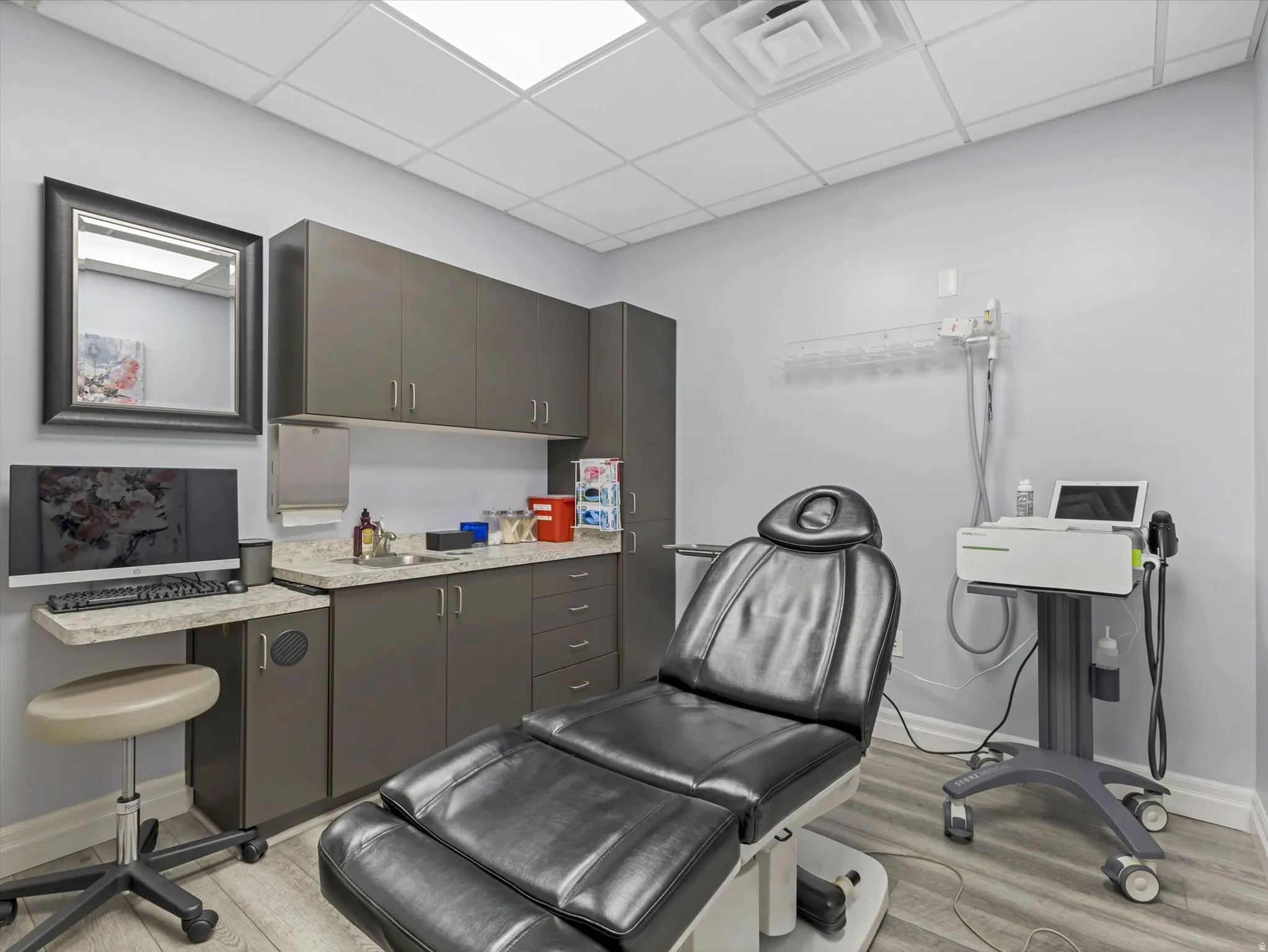 Office area featuring a drop ceiling and a sink