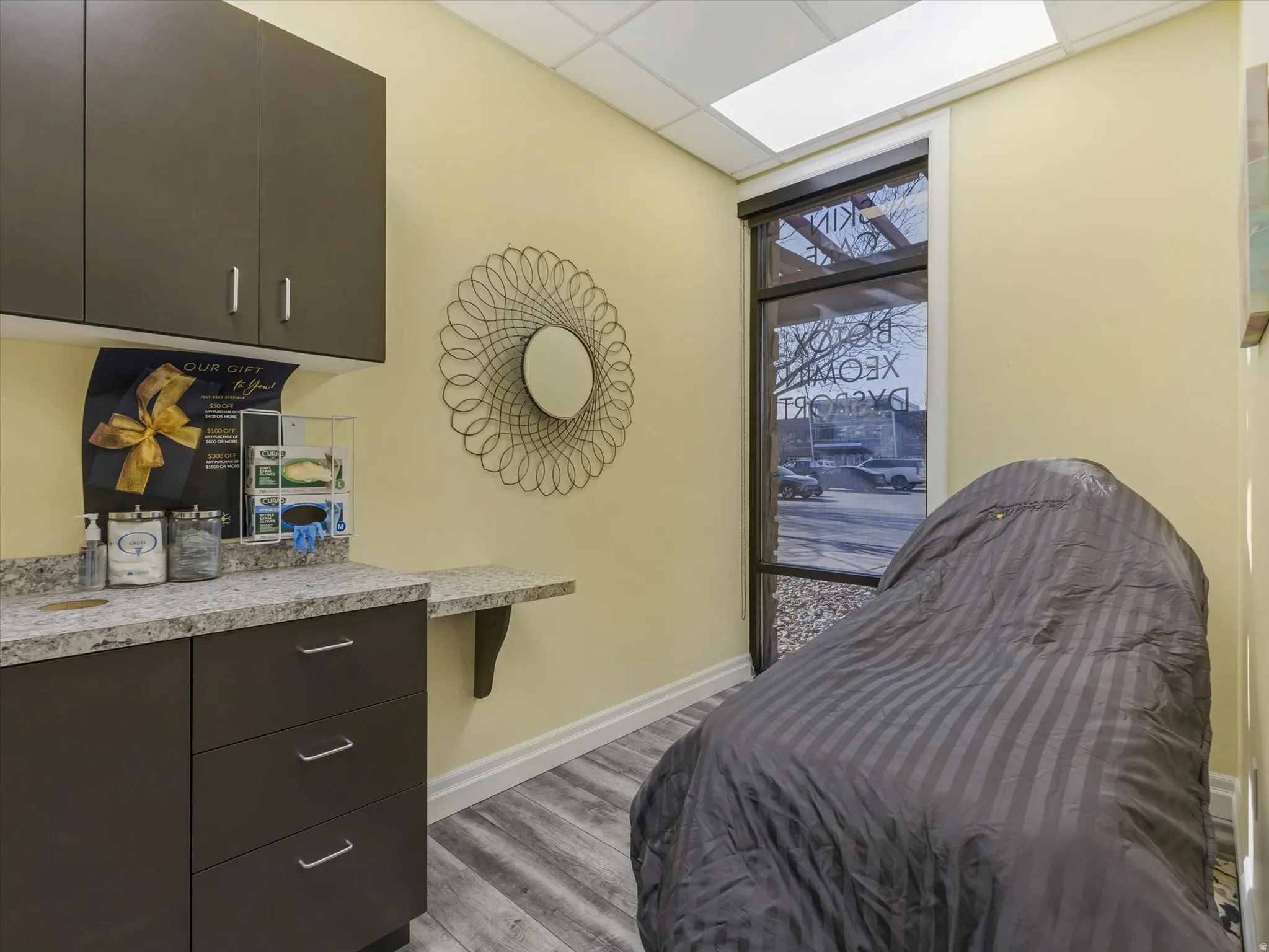 Bedroom with a drop ceiling and light wood-type flooring