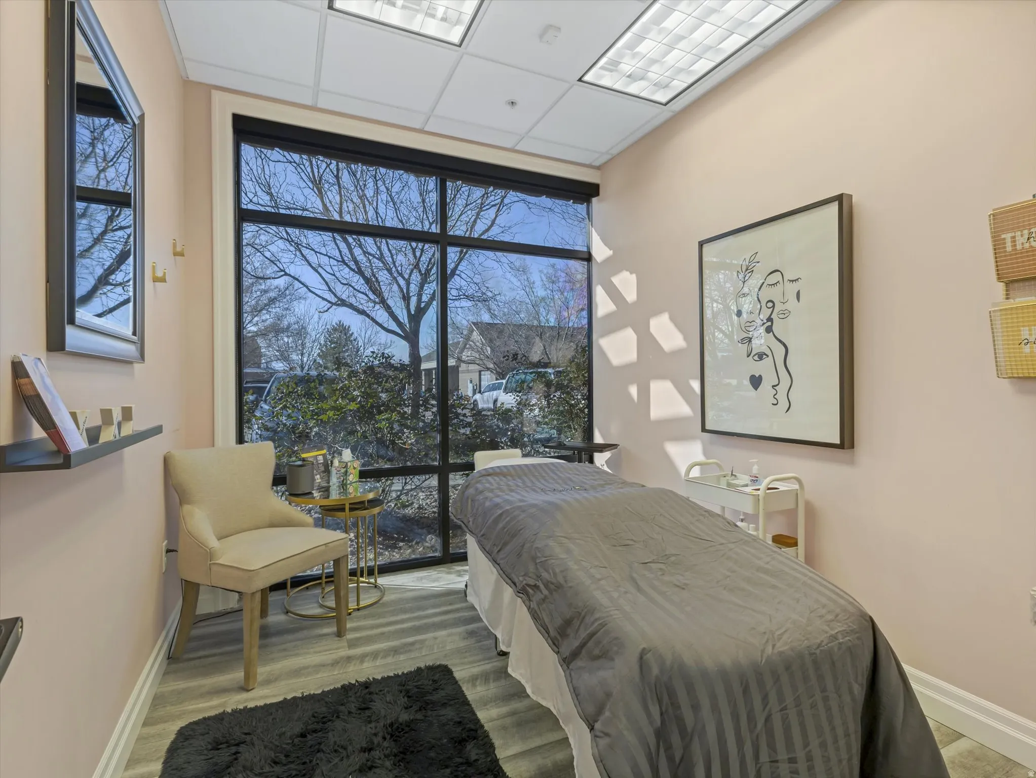 Bedroom with expansive windows, a drop ceiling, and light wood finished floors