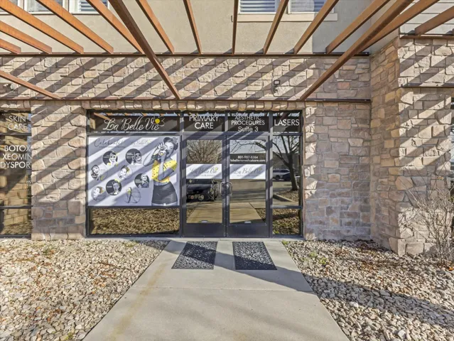 View of exterior entry featuring french doors and a pergola