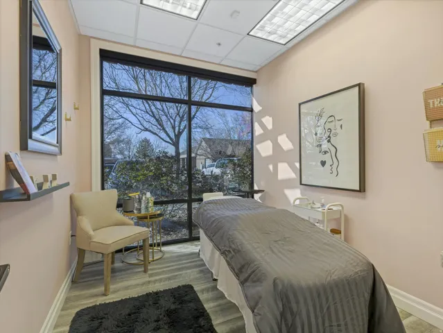 Bedroom with expansive windows, a drop ceiling, and light wood finished floors