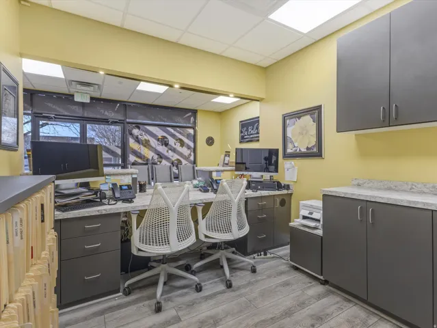 Office space featuring a drop ceiling, built in desk, and radiator heating unit