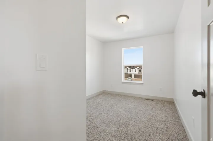 Unfurnished room featuring light colored carpet and baseboards