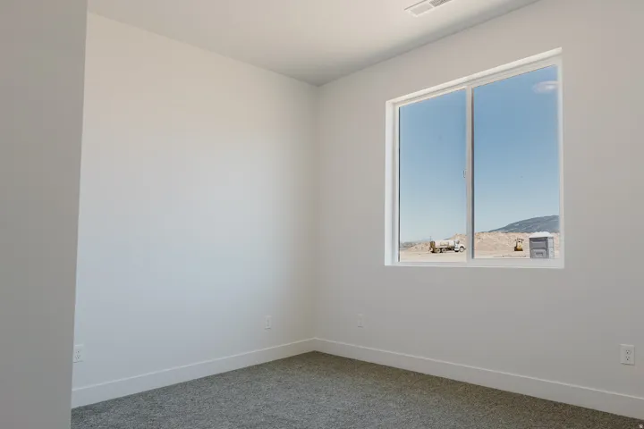 Empty room featuring baseboards and carpet flooring