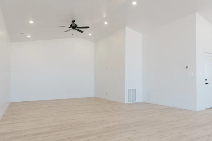 Spare room featuring light wood-type flooring, lofted ceiling, recessed lighting, and a ceiling fan