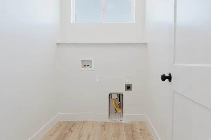 Laundry room with light wood finished floors, hookup for a washing machine, and electric dryer hookup