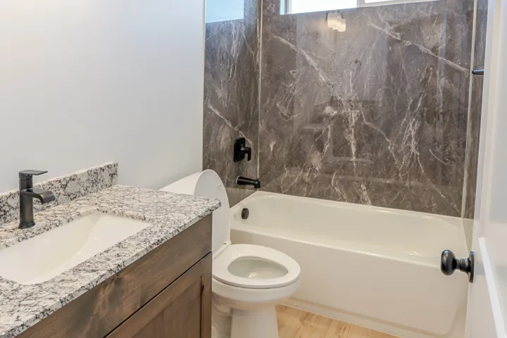 Bathroom with vanity, shower / washtub combination, and light wood-style flooring