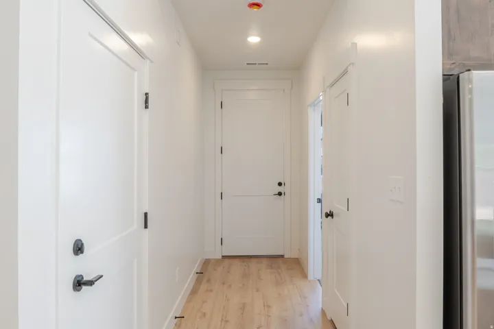 Corridor with light wood-style flooring and recessed lighting